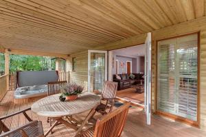 een houten veranda met een tafel en stoelen op een terras bij Willow Lodge, South View Lodges, Exeter in Exeter