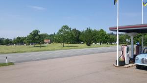 a gas station with a car parked next to a road at Gamla Macken in Margretetorp