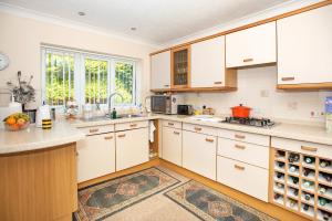 a kitchen with white cabinets and a large window at Luxury House in Warsash. in Warsash