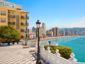 Światło uliczne obok budynku i oceanu w obiekcie Hotel Boutique Villa Venecia w mieście Benidorm