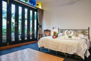 een slaapkamer met een bed en een groot raam bij Ohana House HQ in Melaka