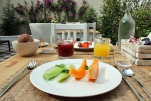 un piatto di frutta su un tavolo con bevande di I Colori della Puglia Rooms a Trani