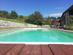 - une piscine d'eau bleue sur une terrasse en bois dans l'établissement LA GRANGE BONAL, à Villette