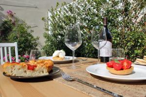 a table with plates of food and a bottle of wine at I Colori della Puglia Rooms in Trani +83 photos
