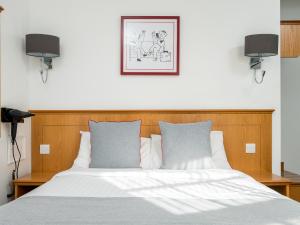 a bedroom with a bed with two monitors on the wall at OYO Townhouse New England, London Victoria in London