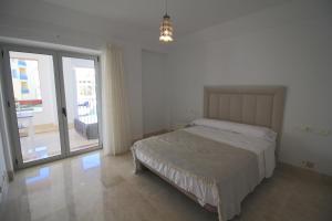 a bedroom with a bed and a sliding glass door at Sotogrande - SotoLUX in Sotogrande +12 photos
