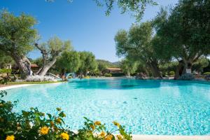 ein großer Pool in einem Park mit Bäumen in der Unterkunft Villaggio Blue Marine in Marina di Camerota