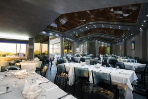 ein Esszimmer mit weißen Tischen und Stühlen in der Unterkunft Villaggio Blue Marine in Marina di Camerota