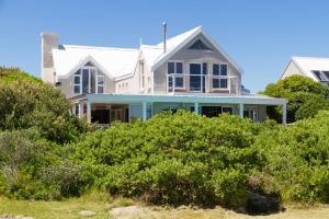 a house on the beach with bushes at Fin Whale Beach House in Kommetjie