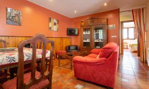 クディレロにあるApartamentos Rurales Villa de Sain Cudilleroのオレンジ色の壁のリビングルーム(ベッド、椅子付)