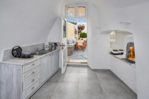 a kitchen with a sink and a fireplace at Day One Fira Mansion in Fira