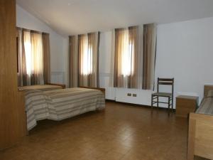 een slaapkamer met 2 bedden en een stoel. bij Casa Montana S. Maddalena in San Vito di Cadore