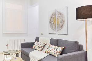 sala de estar con sofá gris y lámpara en LEEWAYS APARTMENT IX in GRAN VÍA, en Madrid