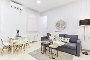 sala de estar con sofá azul y mesa en LEEWAYS APARTMENT IX in GRAN VÍA, en Madrid