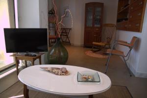 ein Wohnzimmer mit einem weißen Tisch und einem TV in der Unterkunft Bel's Home in Sant Feliu de Guixols