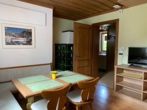 comedor con mesa, sillas y TV en Haus Tirol, en Leogang