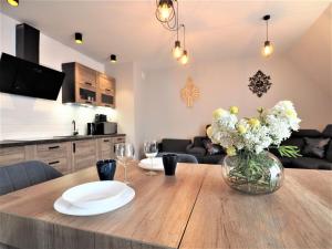 a dining room table with a vase of flowers on it at VIP Apartamenty FOLK RESIDENCE in Zakopane