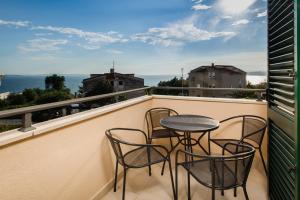 a balcony with three chairs and a table on it at NERA lux apartment in Podstrana