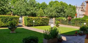 a garden with green grass and bushes and trees at La Casa di Tino in Fontanellato