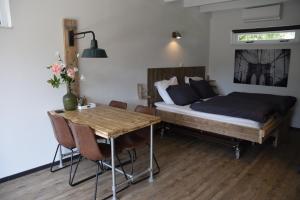 1 dormitorio con cama, mesa y escritorio en Bed & Breakfast "Aan de Bagijnstraat". en Heumen