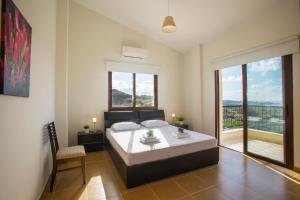 a bedroom with a large bed and a balcony at Villa Blue Jadeite in Peyia +24 photos