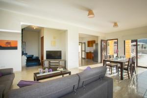 a living room with a couch and a table at Villa Blue Jadeite in Peyia