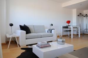 a living room with a white couch and a table at Panoramic Living in Lisbon