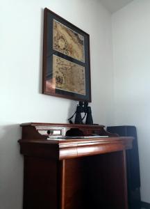 a wooden desk with a picture on the wall at The Garden of Elaïs in Šibenik
