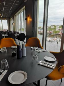 una mesa en un restaurante con vistas al agua en The Tide - Rorbuer, en Sørvågen