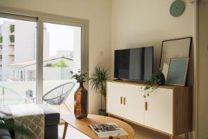 ein Wohnzimmer mit einem TV und einem Tisch in der Unterkunft Phaedrus Living: City Centre Luxury Flat Esperidon 201 in Nikosia