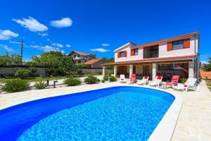 a villa with a swimming pool and a house at Villa Ivana ZadarVillas in Lisičići