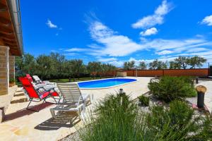 a patio with two chairs and a swimming pool at Villa Ivana ZadarVillas in Lisičići