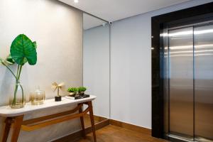 a room with a glass door and a table with plants at Dr. Marinho Apart Hotel in Vitória da Conquista