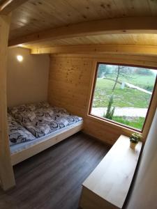 Bett in einem Zimmer mit Fenster in der Unterkunft Estate Marjetin dom in Idrija