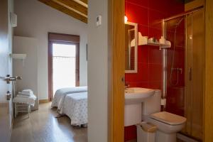 a bathroom with a sink and a toilet and a bed at Casa Rural Villazón II - A 16 km de Pamplona in Obanos
