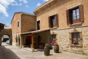 a brick building with two barrels in front of it at Casa Rural Villazón II - A 16 km de Pamplona in Obanos