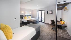 a hotel room with two beds and a desk at Bank Square Town House in Belfast