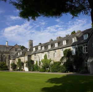 a large building with a green lawn in front of it at Dartington Hall in Totnes