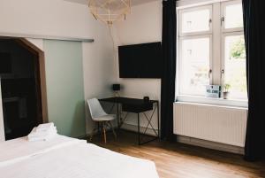 ein Schlafzimmer mit Bett, Schreibtisch und Fenster in der Unterkunft Hotel Palmenbad in Kassel