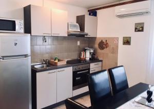 a small kitchen with a sink and a stove at Apartment Garden in Slunj