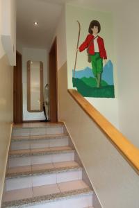 une fresque d'un homme marchant dans les escaliers dans l'établissement Rooms Zupančič, à Bohinjska Bela