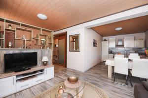 a living room with a television and a kitchen at Villa Ivana ZadarVillas in Lisičići