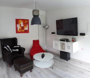 a living room with a black chair and a tv at Arthouse Apartment 2 in Bad Vilbel