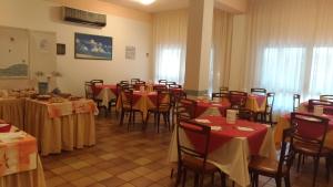 un comedor con mesas y sillas rojas y amarillas en Hotel Sirena, en Bellaria-Igea Marina