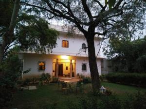 a white house with a table and chairs in the yard at Kawa Guest House in Jaipur