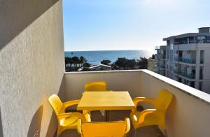 a table and chairs on a balcony with the ocean at Apartamente Antoni Shengjin in Shëngjin