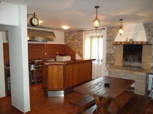 eine Küche mit einem Holztisch und einer Theke darin in der Unterkunft Hodak Apartment in Nerezine