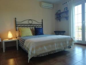 um quarto com uma cama grande com almofadas azuis e amarelas em Isla Canela Golf em Ayamonte