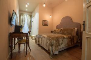 1 dormitorio con cama, mesa y escritorio en Le Camere Di Boccanegra, en Sarzana