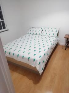 Cama en habitación con sábana blanca en Esthela home, en Funchal